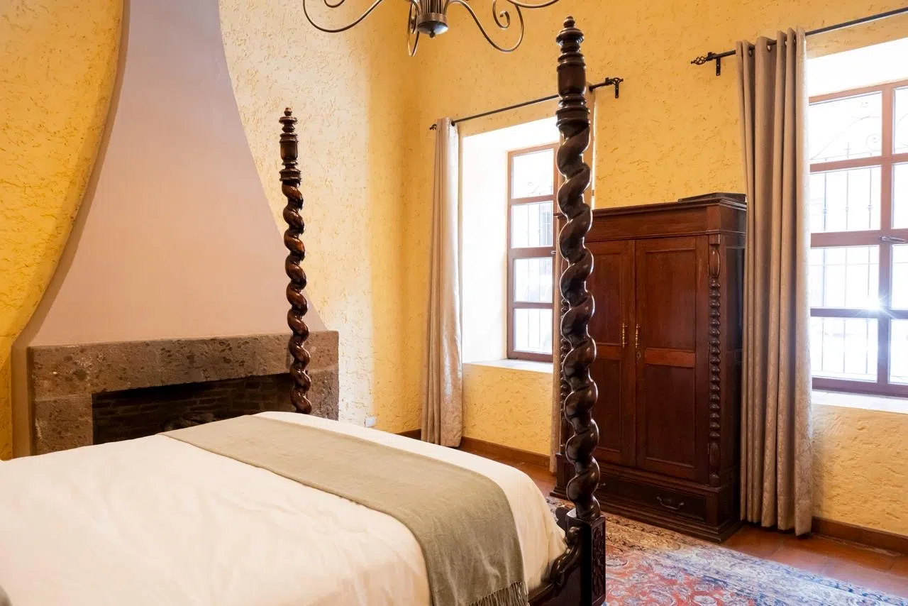 Habitación Tlaui con cama queen de postes torneados y chimenea de cantera, Hotel Xacalli San Miguel de Allende